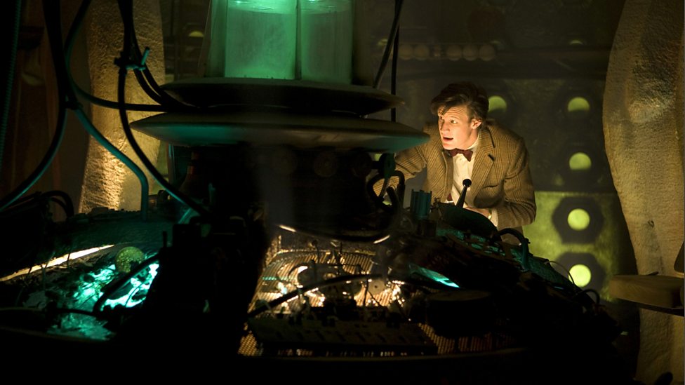 The Eleventh Doctor stands at the TARDIS console of his 9th and 10th incarnations.